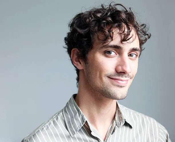 files/curly-haired-dimply-cheeked-man-smiling-portrait.webp